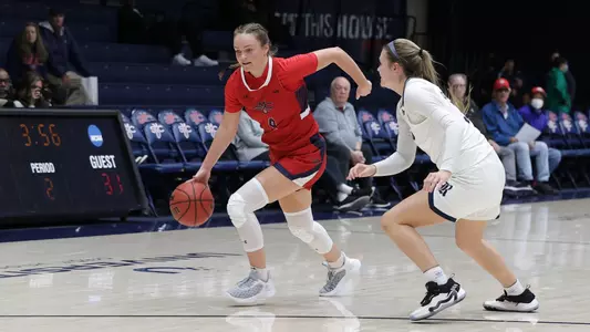 Taycee Wedin dribbles around defender near broadcast booth
