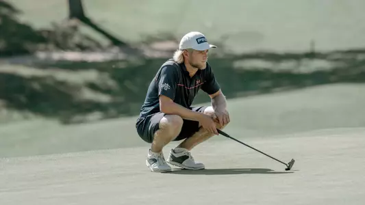 Kristian Bressum crouches down to measure up a put