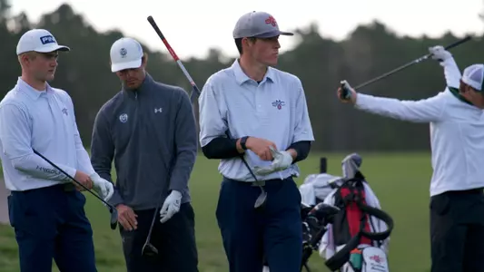 Connor Reis puts on gloves before teeing off