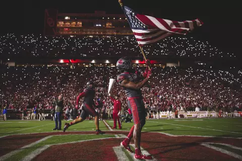 Oklahoma defensive back Robert Spears-Jennings runs onto the field with an American flags prior to the game against West Virginia on Nov. 11, 2023 in Gaylord Family-Oklahoma Memorial Stadium in Norman, OK. (Photo by Morgan Givens/Oklahoma Athletics)