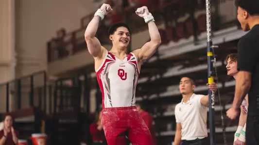 Emre Dodanli celebrates his high bar dismount in a meet at McCasland Field House