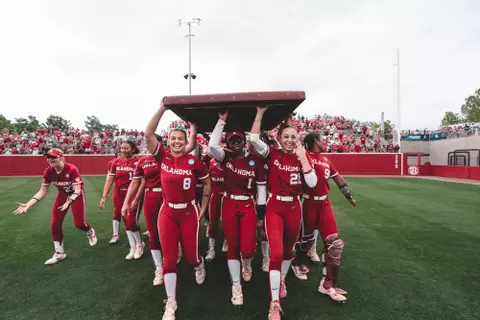 NORMAN, OK - May 24, 2025 - Oklahoma Pitcher Isabella Smith (#8), Oklahoma Infielder Cydney Sanders (#1), Oklahoma Pitcher Sam Landry (#21) and team celebrate the outfield wall tradition during the 2025 Norman Super Regional game between the Alabama Crimson Tide and the Oklahoma Sooners at Love's Field in Norman, OK. Photo By Morgan Givens/University of Oklahoma