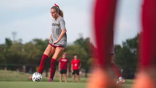 Ally Laccinole kicking a ball in warmups against Oklahoma State