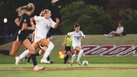 Michelle Pak dribbling the ball up the pitch in a game against Florida