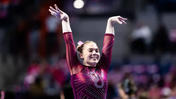 Lily Pederson salutes the judges at Oklahoma's meet against Florida