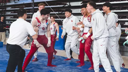 OU men's gymnastics team celebrates Kelton Christiansen's high bar dismount in OU's win over Ohio State and Air Force at McCasland Field House