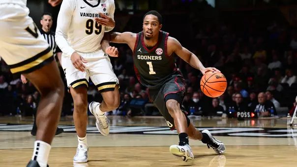 Xzayvier Brown drives around Vanderbilt defenders in OU men's basketball game at Vanderbilt's Memorial Gymnasium