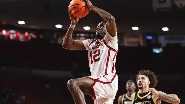OU's Jadon Jones in white uniform goes up for a dunk against Missouri (defenders in black uniform pictured trailing) at Lloyd Noble Center on March 3, 2026.