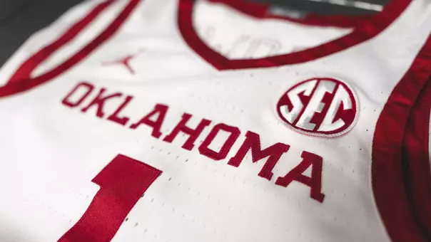 Close-up photo of white Oklahoma basketball jersey with text "Oklahoma," an SEC patch and the number 1
