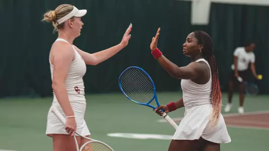 Gloriana Nahum and Roisin Gilheany celebrate after winning a point in doubles play.
