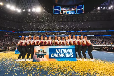 The Oklahoma women's gymnastics team poses with the 2026 National Championship Trophy.