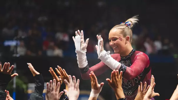 Ella Murphy giving teammates high fives after bars at the 2026 SEC Championship