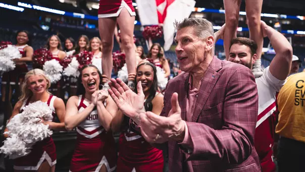 Porter Moser claps surrounded by spirit squad after a win at Lloyd Noble Center