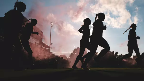 Picture of the team running onto the field at John Crain