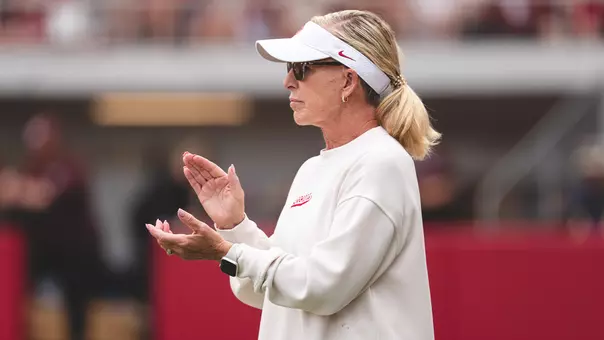 Picture of OU Softball head coach Patty Gasso coaching third base during a game against Mississippi State