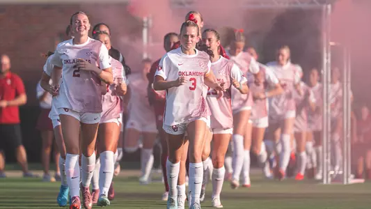 Lexi Dendis and Paige Califf running out on the field