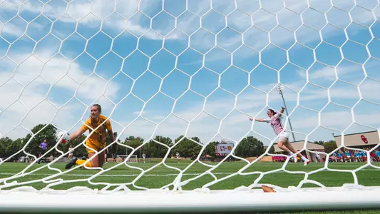 Sophie Morrin in the background celebrating an Oklahoma goal after the ball goes into the back of the net.