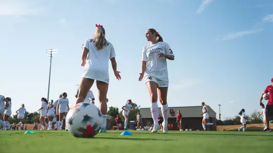 Lexi Dendis and Sadie Sterbenz high fiving on the pitch prior to a game