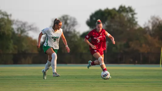 Lexi Dendis dribbling the ball up the field against North Texas