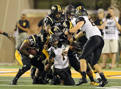Sep 20, 2014; Hattiesburg, MS, USA; Southern Miss Golden Eagles defensive lineman Dasman McCullum (45) strips the football from Appalachian State Mountaineers running back Marcus Cox (14), center, in the third quarter of their game at M.M. Roberts Stadium. Southern Miss won, 21-20. Mandatory Credit: Chuck Cook-USA TODAY Sports