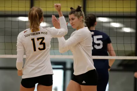 Cara Atkinson (1) celebrates with Lindsey Legg (13) after a kill against South Alabama