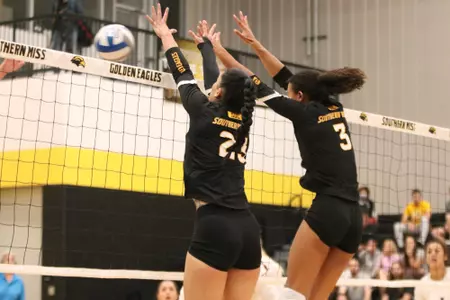 Mia Wesley (23) and Ari Barksdale (3) collect a block assist against Troy