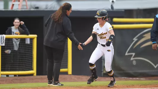 Southern Miss Golden Eagles outfield Lorna Agren (10) celebrates with Southern Miss Head Coach Natalie Poole after hitting a home run
in a game between the Southern Miss Golden Eagles and the Southern University February 15, 2023 (Joe Harper/bgnphoto.com)