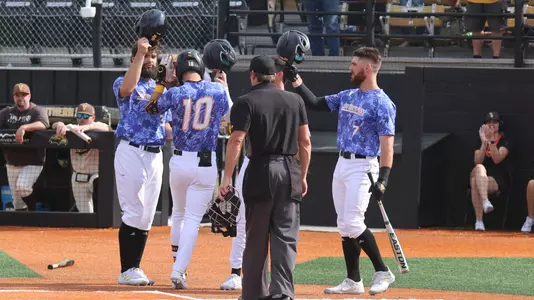 Southern Miss. infielder Dustin Dickerson (10) gets congratulated at home plate by Southern Miss. outfielder Matthew Etzel (3) and Southern Miss. outfielder Slade Wilks (7) in a game between the Southern Miss Golden Eagles and Valparaiso. March 11, 2023 (Joe Harper/bgnphoto.com)
