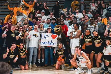 Men's Basketball players pose with fans following game