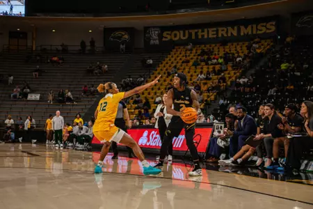 Ramiah "Moonie" Augurson holds the ball in front of Southern Miss' bench