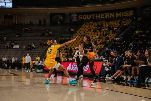 Ramiah "Moonie" Augurson holds the ball in front of Southern Miss' bench