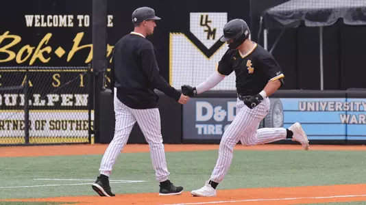 Southern Miss. infielder Davis Gillespie (11) celebrates the home run with Assistant coach Travis Creel in a game  between the Southern Miss Golden Eagles and UNC Wilmington in the NCAA  baseball game.  March 09, 2025 (Joe Harper/bgnphoto.com)