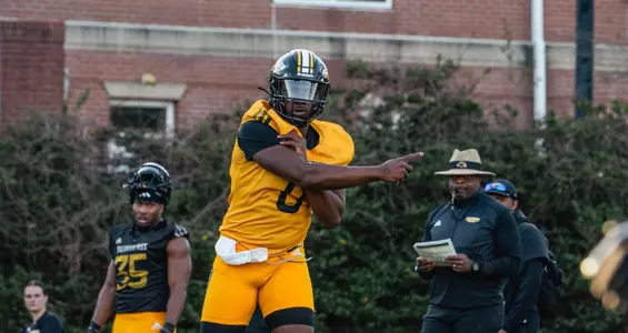 Braylon Braxton throws in spring practice with Charles Huff looking on