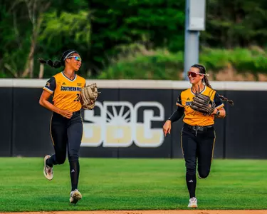 Kinsley Gordon-Sivley and Adryan Cox running in after the inning