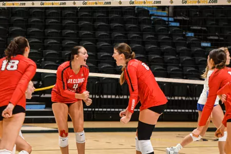 Freshman outside hitter Abby Wachal (4) and senior outside hitter Kenzie Foley (8) celebrate a point during St. Cloud State's win over Alaska Fairbanks on August 31, 2023.