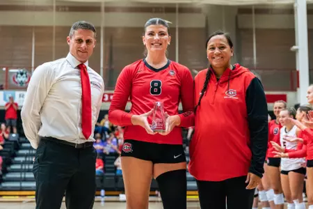 Kenzie Foley AVCA DII Player of the Year trophy with Chad and Marci