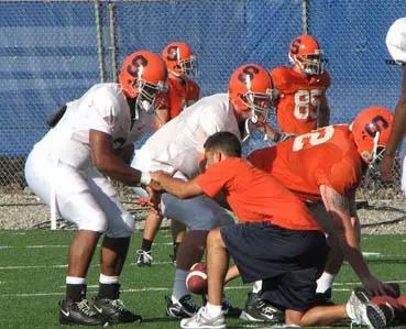 Orange Signal Callers Pushing Each Other in Camp Image