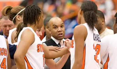 Coach Hillsman leads his team in a huddle.