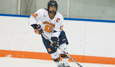 Julie Rising skating with the puck.