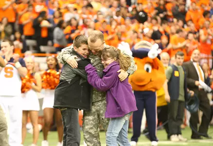 U.S. Army father embraces children after returning home from Afganistan to suprise family at the Carrier Dome on Oct. 21 vs. WVU