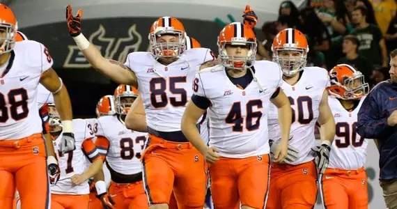 Beckett Wales, with arms up, runs onto the field prior to the start of the game.