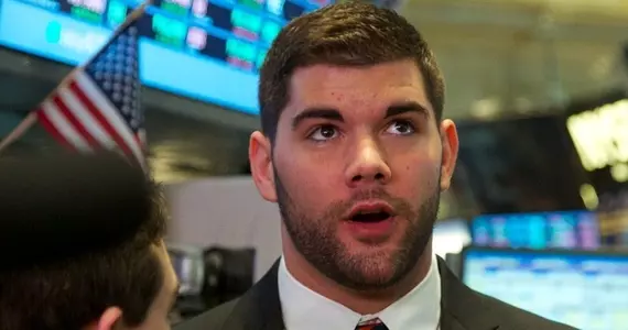 Justin Pugh looks up at the stock ticker as he talks to reporters.