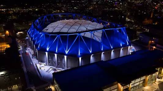 An aerial shot of the Syracuse University Stadium lit up at night.