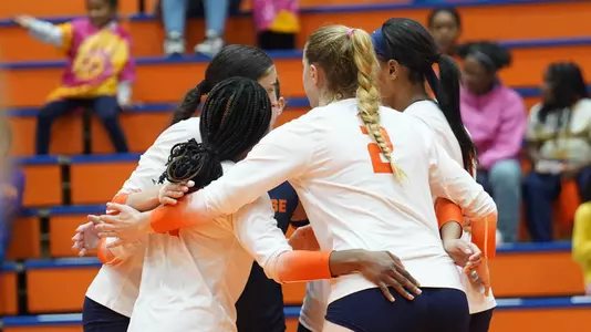 Volleyball team huddles after a point against Clemson