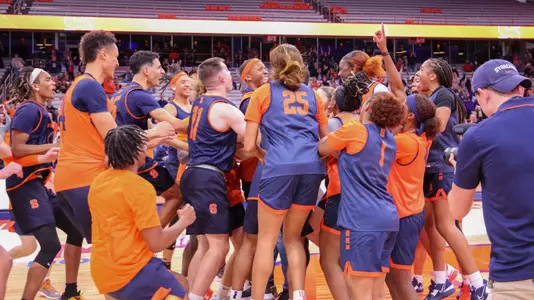 Players from the Syracuse men's and women's basketball team celebrate at the JMA Wireless Dome