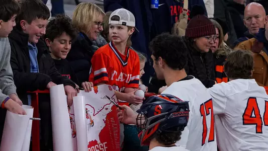 Men's Lacrosse Players Signing Posters after the game