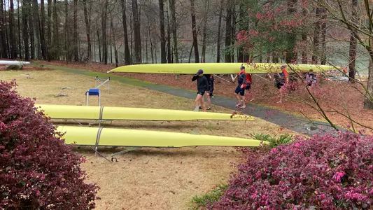 Men's rowing carries a shell off the water in Clemson, SC
