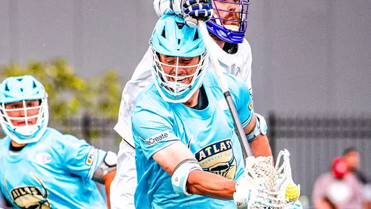 Peter Dearth protects his lacrosse stick from an over-the-head-check by a Waterdogs defender.