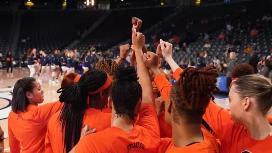 Women's Basketball team huddles at a game.