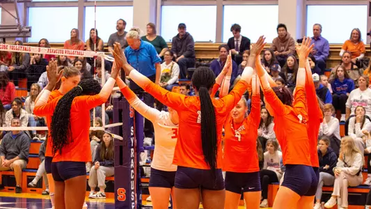 Volleyball huddle in front of home crowd